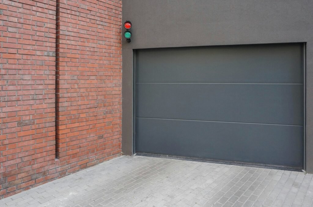 Grey garage door next to brick wall